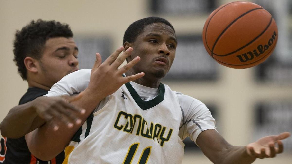 Conway guard Darren Stanley (11) goes for an errant pass against Martinsburg’s Jalen Hesen (33) during a first-round game in the Panther Classic at Carolina Forest High.
