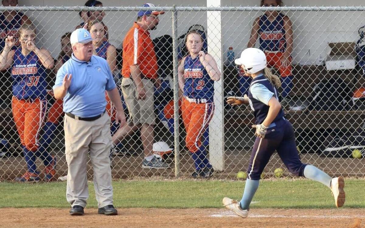 Aynor softball coach Tony Mills congratulates a Blue Jackets player rounding third base following a home run last season. More than a week ago, the team was accused of using illegal equipment, allegations that were proven to be false.
