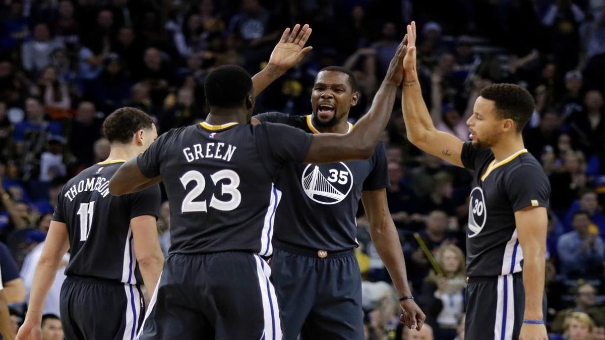 Golden State’s Kevin Durant (35) Draymond Green (23) Stephen Curry, right, high-five one another during the second half of Saturday’s game.