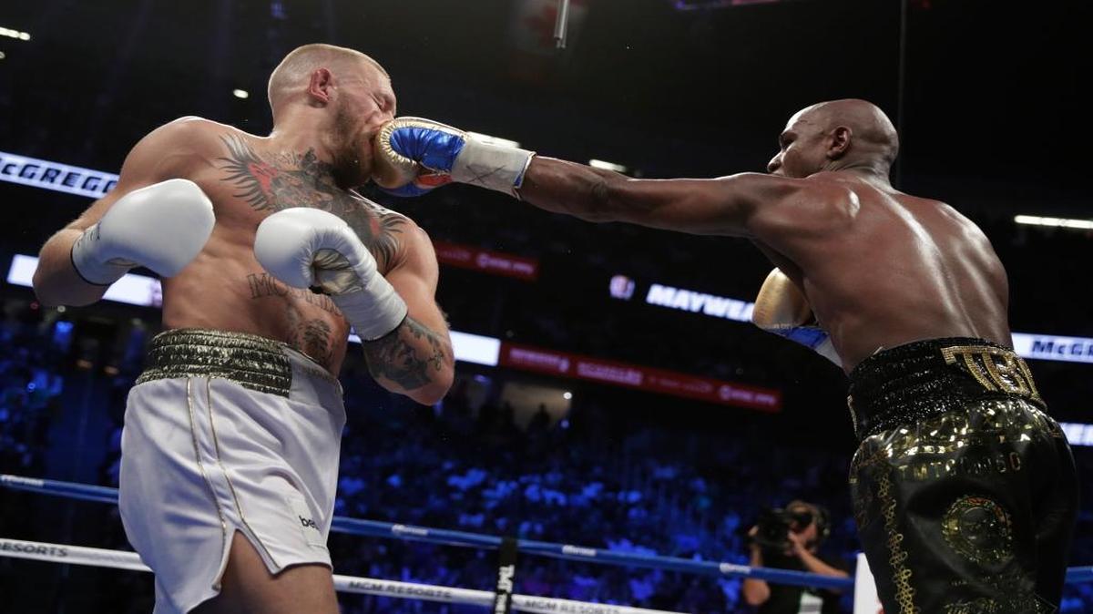 Floyd Mayweather Jr. jabs Conor McGregor in a super welterweight boxing match Saturday.