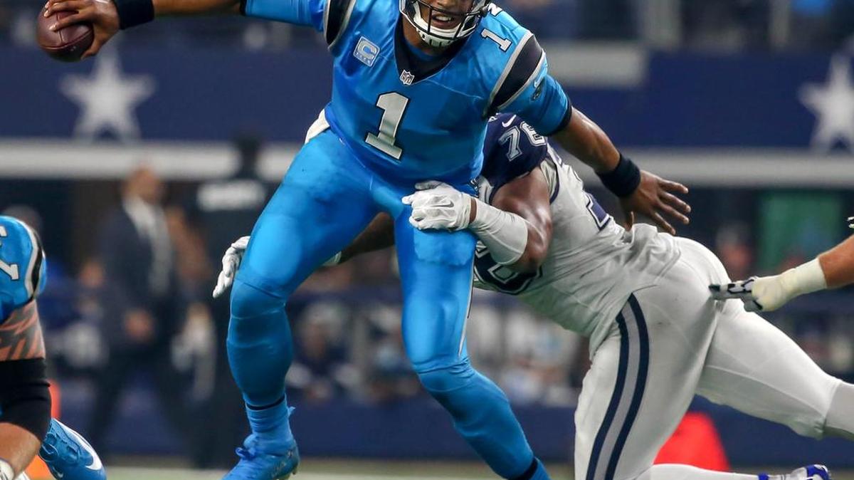 Carolina Panthers quarterback Cam Newton avoided a sack by the Cowboys’ Greg Hardy during the Thanksgiving Day game at AT&T Stadium, where an Panther fan accused a security guard of assault.