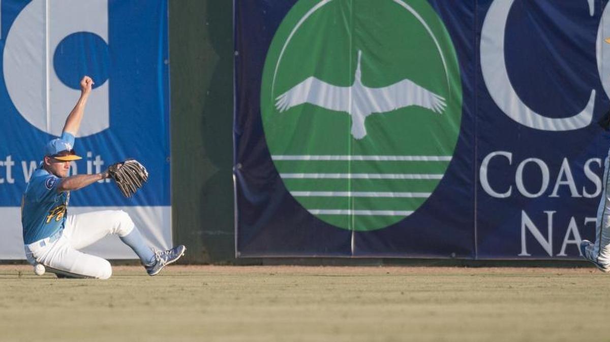 Pelicans outfielder Donnie Dewees slides past the ball in the outfield on Tuesday night.