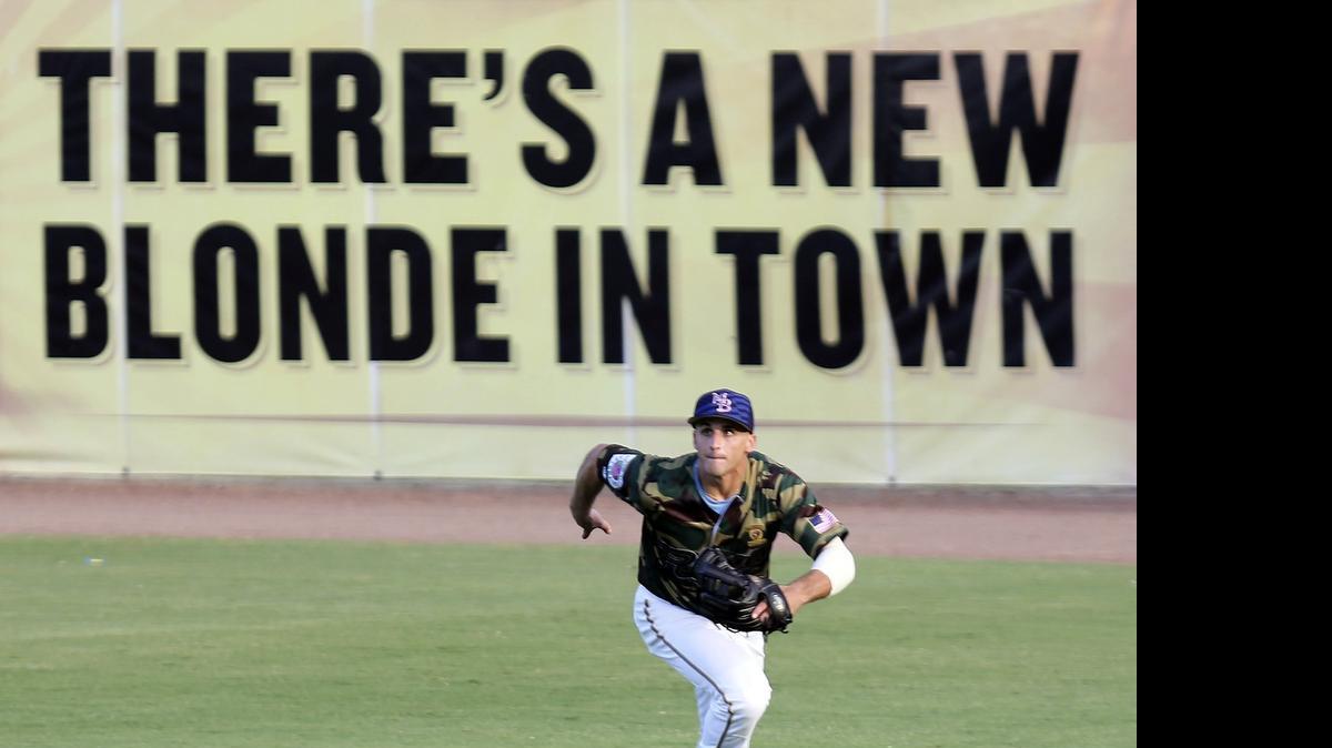 
The Pelicans’ Mark Zagunis runs to a foul ball in front of the Carolina Blonde sign on the right-field wall during Thursday’s game against Salem.
