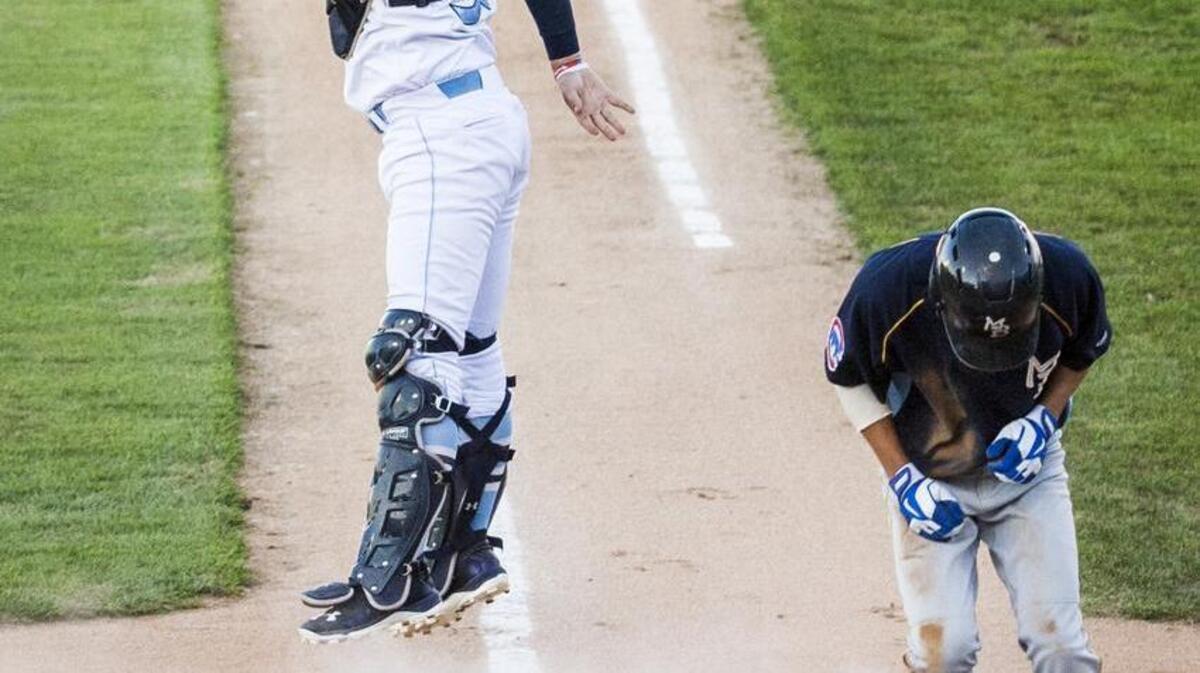 
Wilmington Blue Rocks catcher Cam Gallagher looks back as a throw from right fielder Elier Hernandez sails overhead as Myrtle Beach’s Pin-Chieh Chen slides safely into home plate in the first inning of Monday’s game.
