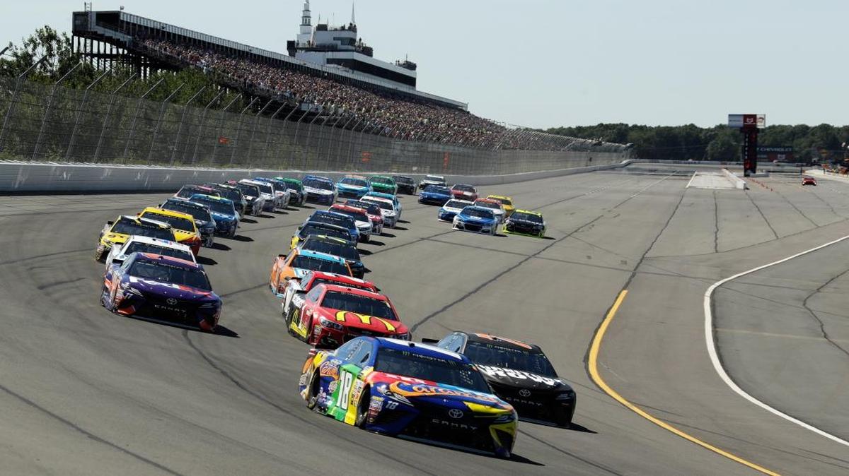 Kyle Busch (18) leads the field on a green flag to start a NASCAR Cup Series auto race at Pocono Raceway on Sunday.