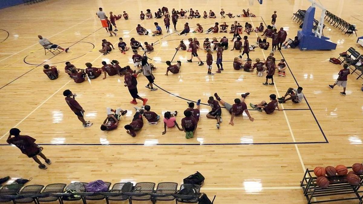 Kids listen to instructors, including Trello Galloway, during Ramon Sessions’ annual youth basketball camp Tuesday.
