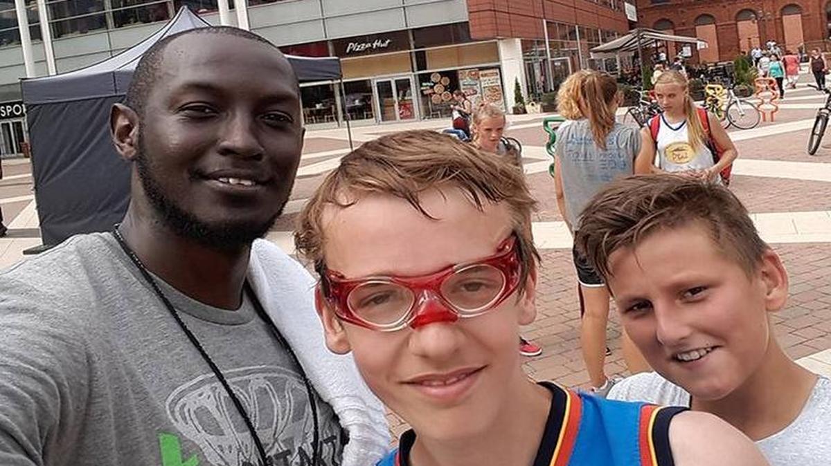 Myrtle Beach native Jeremy Howard (left) takes a selfie with kids while volunteering for a basketball camp last month in Lodz, Poland.