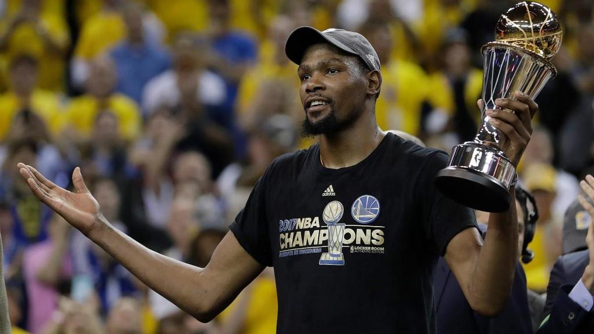 Golden State forward Kevin Durant gestures as he holds the Bill Russell NBA Finals Most Valuable Player Award trophy Monday.