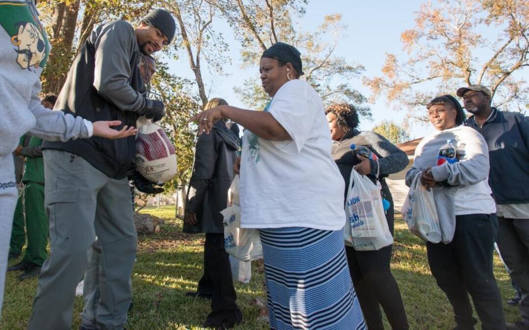 Ramon Sessions hands a turkey to Cherly Morrison during his annual turkey drive in the Racepath community where he grew up.