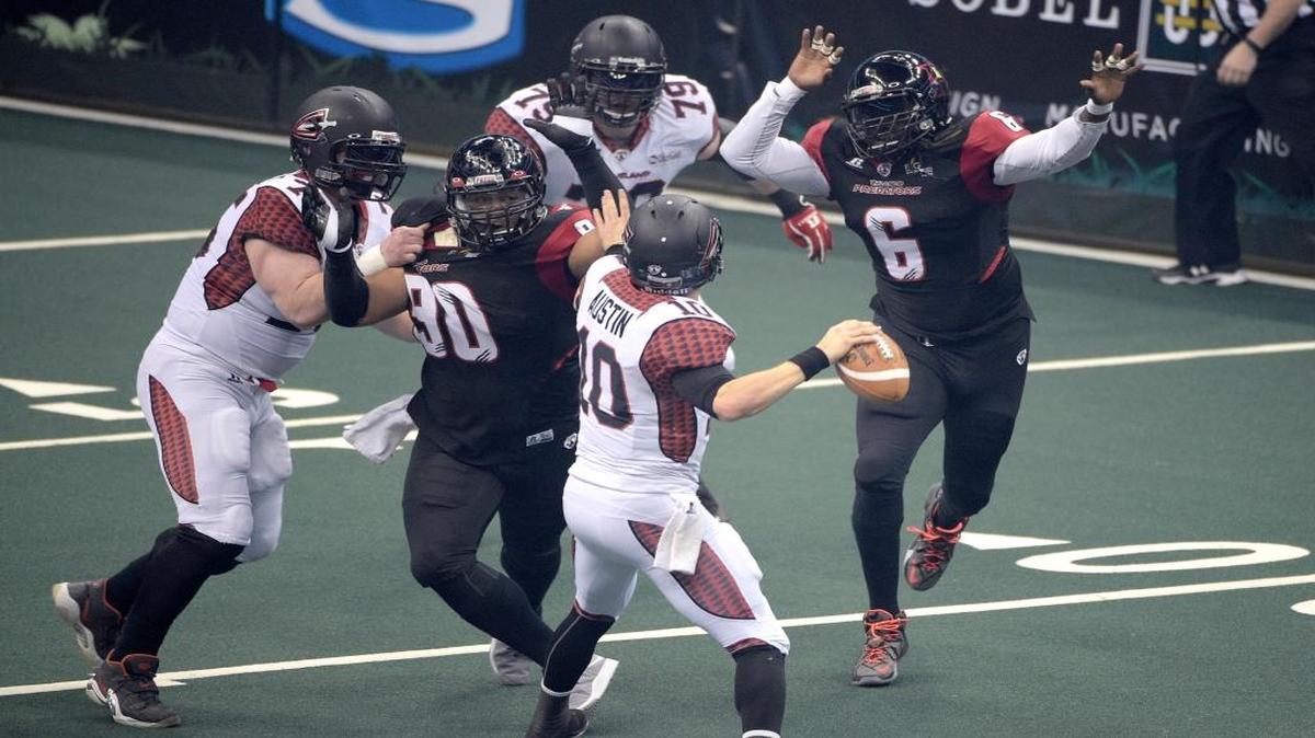 Cleveland Gladiators quarterback Shane Austin (10) is pressured by Orlando Predators defensive linemen Austin Brown (90) and Jeremy Geathers (6) during a game in 2015.