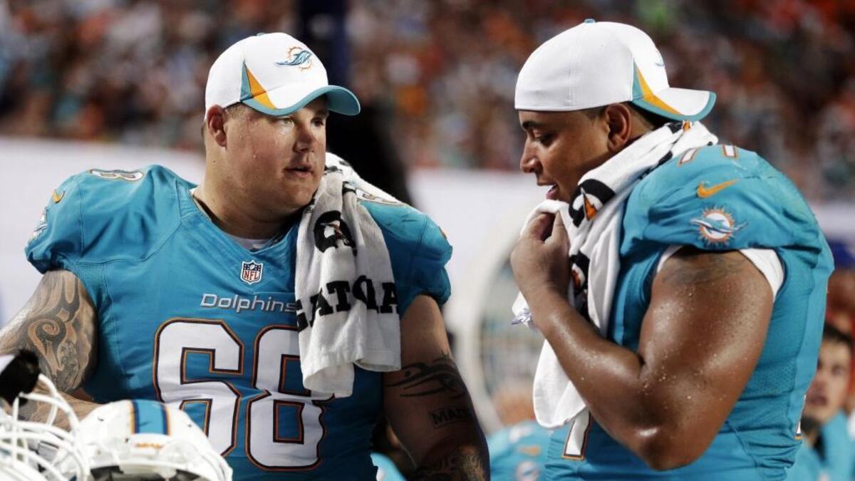 Miami Dolphins guard Richie Incognito (68) and tackle Jonathan Martin (71) look over plays during a game in 2013.