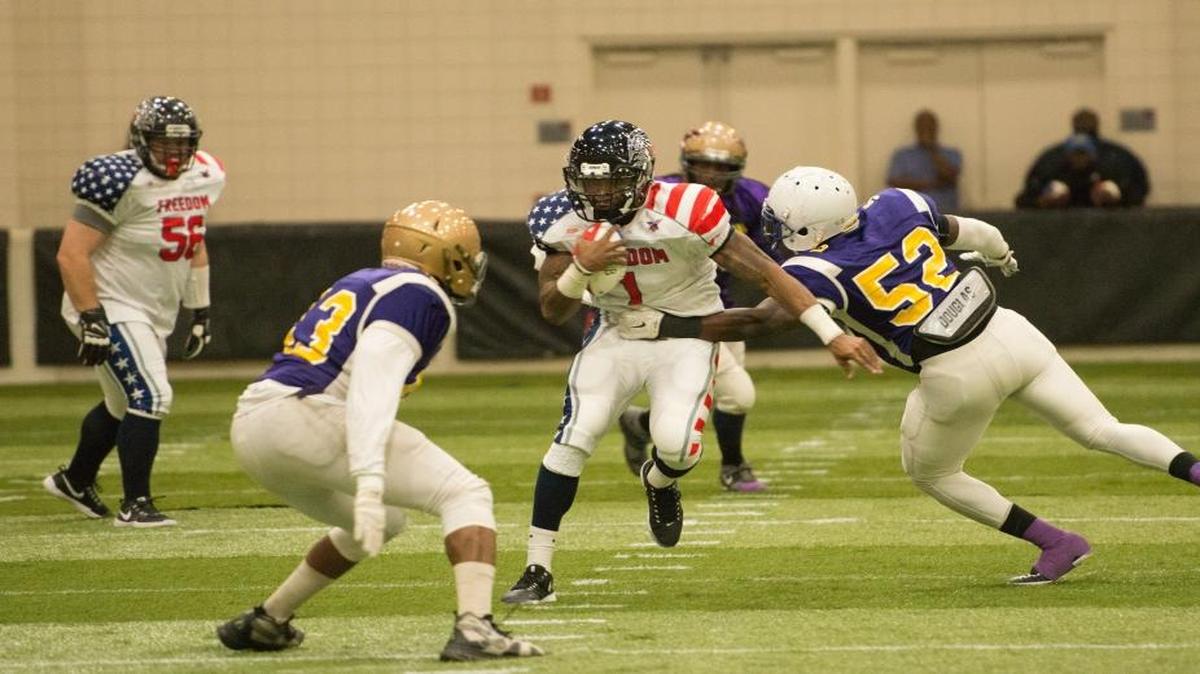Myrtle Beach’s Daryll Clark looks for running room as Carolina Dynasty defenders try to bring him down.