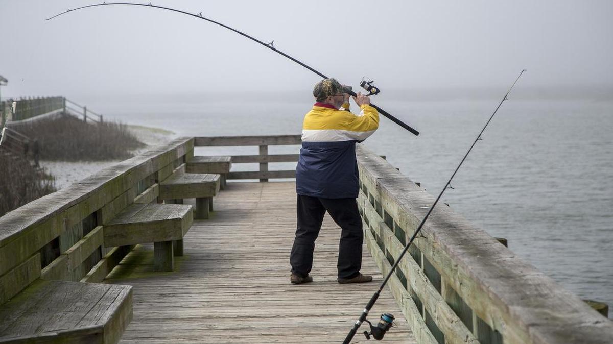 Visiting the area last year from his residential home in Canada, Bruce Laing fishes the Cherry Grove Boat Landing docks.