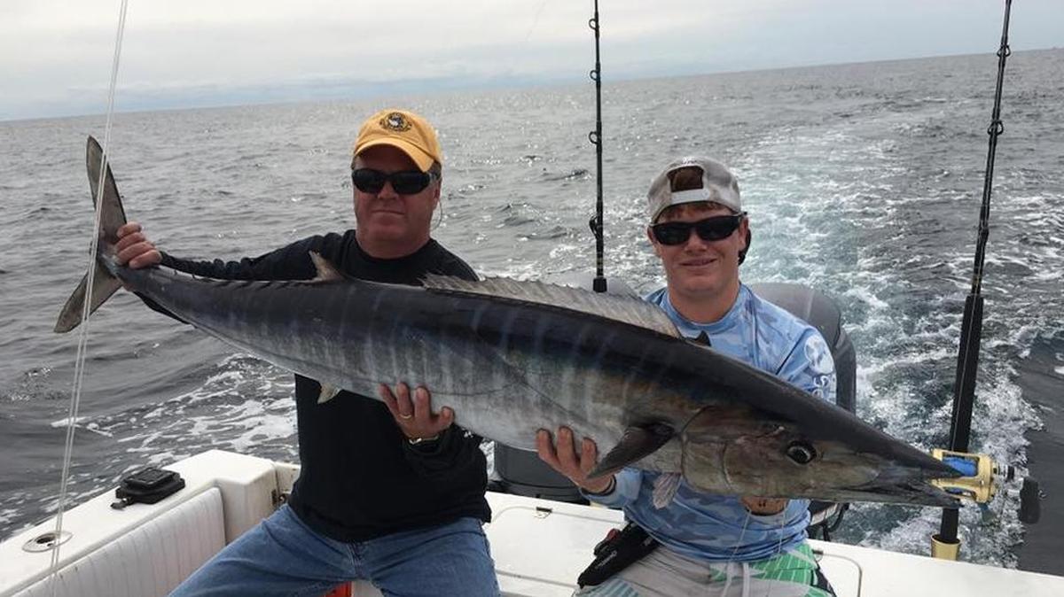 Greg Plummer (left) and Quentin Faulkner show off a wahoo in the 60-pound class caught aboard Fish-A-Holic out of Murrells Inlet Sunday.