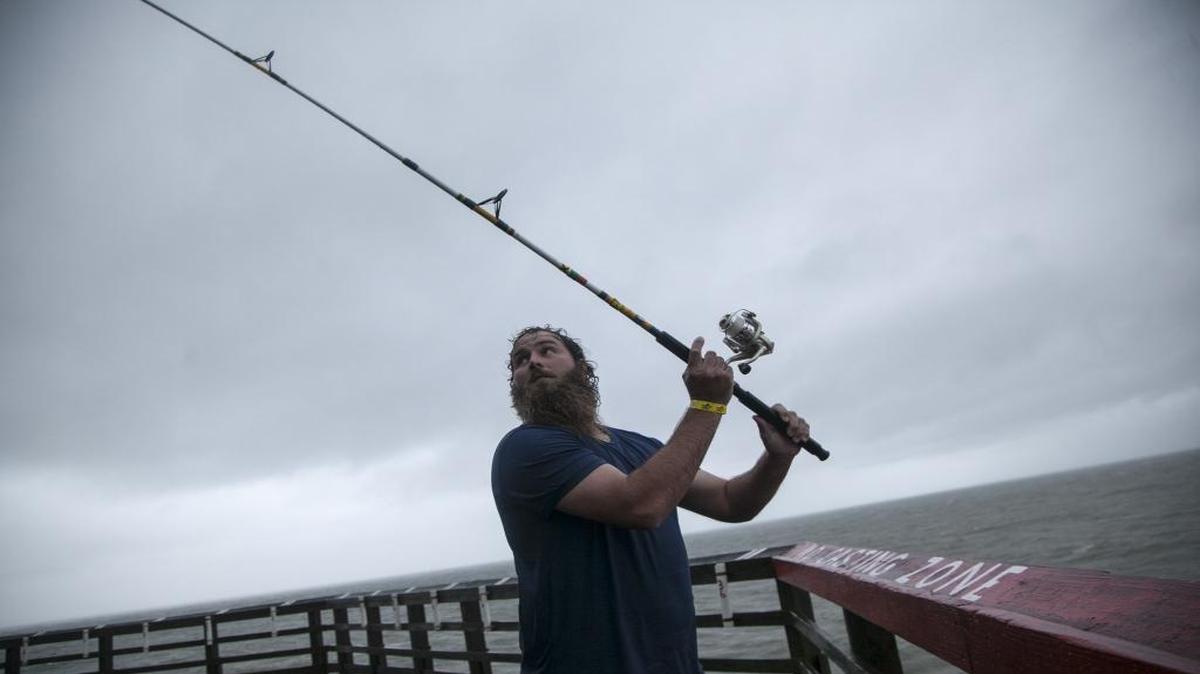 Matt Risenhoover of Cleveland, Tenn., continues fishing off the Cherry Grove pier despite heavy rains and winds brought on by Tropical Storm Hermine a few months ago.