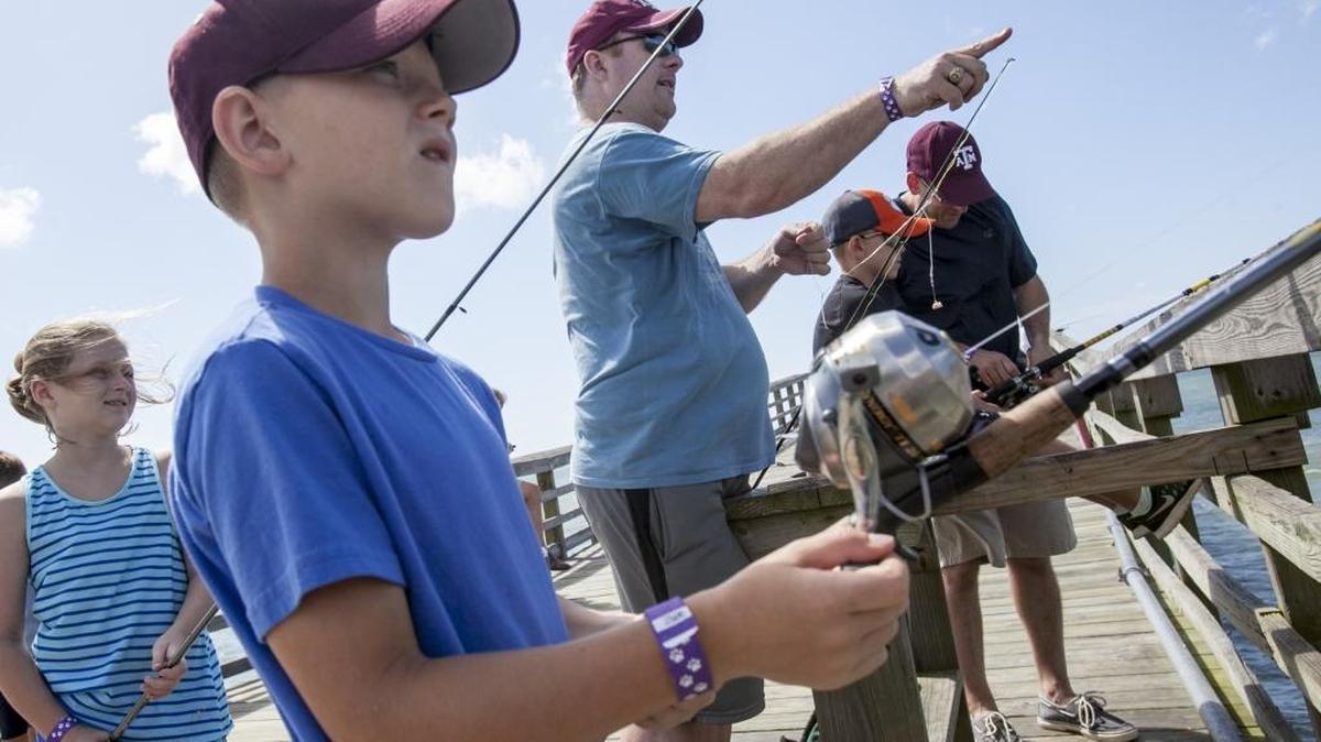 Brothers-in-law Abraham Delange and Brent McCord take their children fishing at Cherry Grove Pier last year.