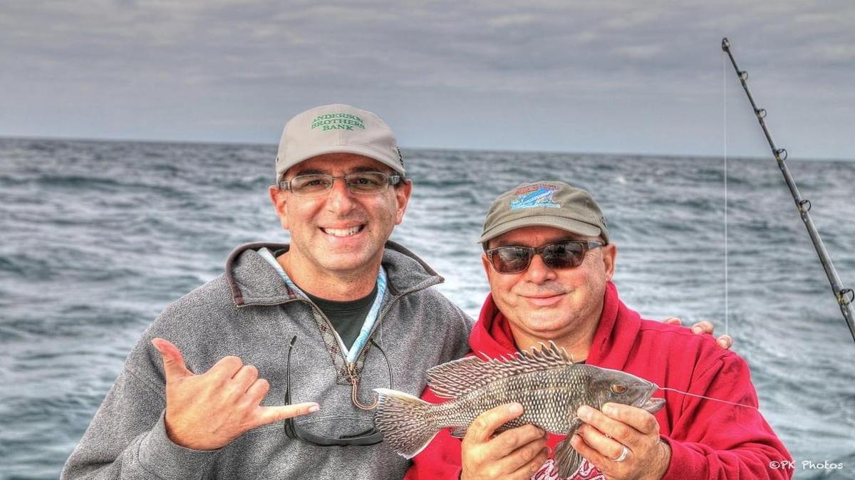 Dr. Jason Rosenberg and Gregg Holshouser show off one of the many 12-inch black sea bass caught during a recent fishing trip out of Murrells Inlet.