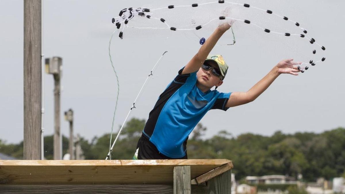 Dylan Garrity, of Berlin, N.J., throws a cast net from the Apache pier in hopes of catching bait.