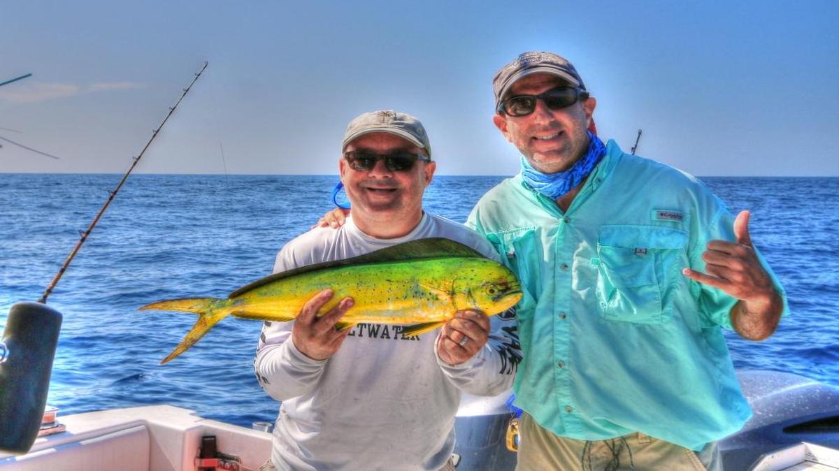 Gregg Holshouser and Dr. Jason Rosenberg display a dolphin caught aboard Painkiller on Wednesday.