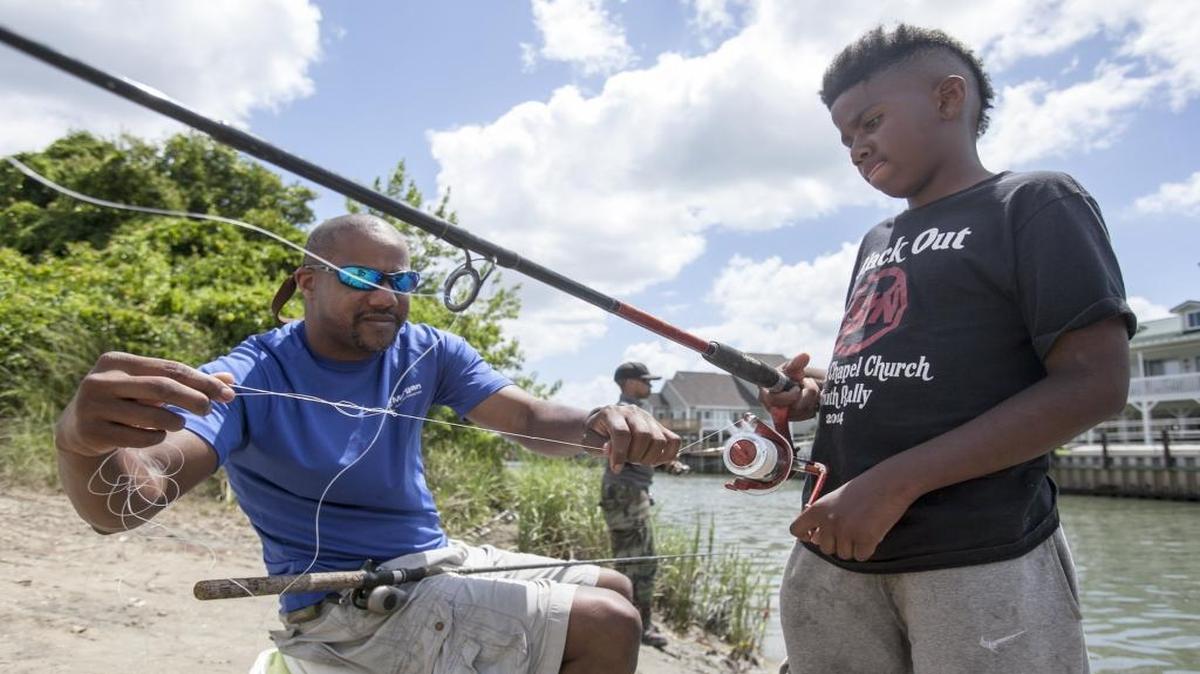 Monque Autry helps untangle his 10-year-old son, Kyle Autry's line during a fishing trip to Cherry Grove last summer.