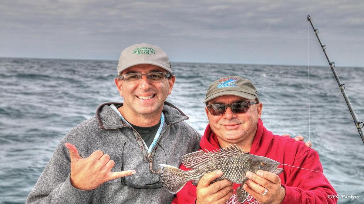 Dr. Jason Rosenberg (left) and Gregg Holshouser display one of many 12-inch black sea bass caught on a Wednesday fishing trip off the coast of Murrells Inlet.