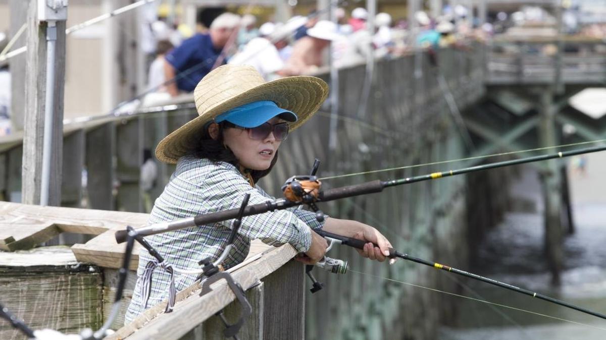 Sun Kim of Fayetteville, N.C., doubles up on hats while fishing the Apache Pier last year.
