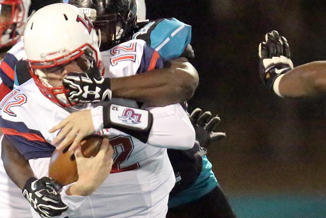 Liberty University’s Stephen Calvert’s head is jerked around by the face mask in a game against Coastal Carolina at Brooks Stadium on Thursday, Nov. 17, 2016.
